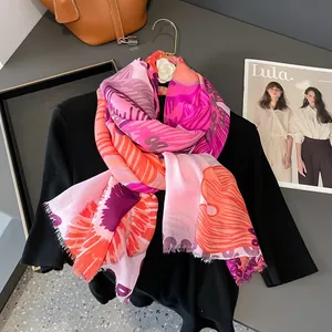 Détail d'une écharpe à imprimé abstrait avec franges délicates sur vêtement noir