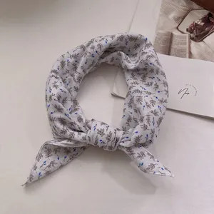 Close-up view of a vintage floral cotton linen square scarf with a stylish knotted detail