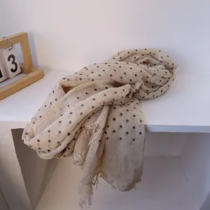 Detail of linen polka dot scarf showing lightweight fabric texture and frayed fringe edges