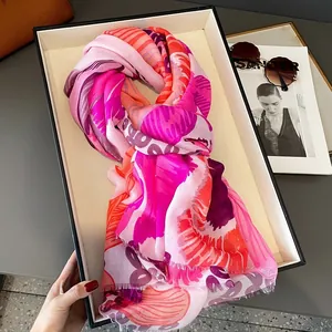 Détail d'une écharpe imprimée colorée avec de courts pompons dans un coffret cadeau
