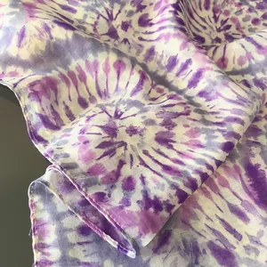 Vista macro dell'estremità della sciarpa di seta con motivo tie-dye viola e bordi rifiniti