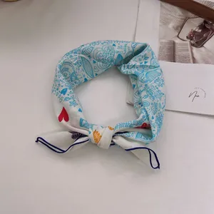 Close-up of cotton linen bandana with colorful doodle prints tied in a decorative knot