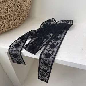 Détail d'un ruban en dentelle noire élégante avec broderie florale fine et bords festonnés