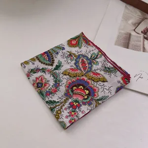 Detail of vintage paisley cotton bandana featuring floral prints and hand-rolled red edges