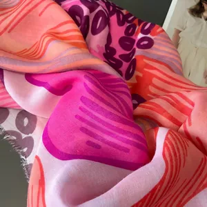 Détail d'une écharpe imprimée abstraite montrant la texture du tissage et les bords