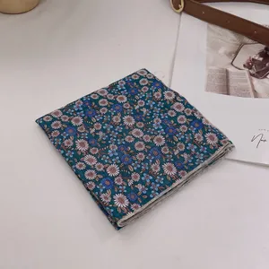 Detailaufnahme des dunkelblauen Baumwolltuchs mit Gänseblümchenmuster und feiner Naht