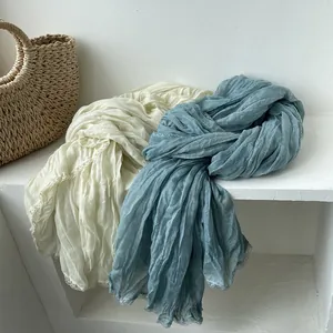 Sciarpa in cotone e lino color crema e blu grigio con trama plissettata e bordo in pizzo