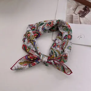 Detail of vintage paisley cotton linen bandana with floral pattern and red hemmed edges