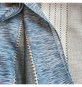 Close-up of fabric edges showing detailed stitching on a blue and brown plaid scarf