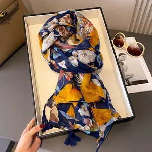 Écharpe bleu foncé avec imprimés floraux jaunes et franges, idéale pour le look d'été