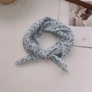 Detail view of cotton linen floral headband with blue leaves and red berry patterns