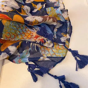 Vue détaillée de l'écharpe à imprimé ananas tropical avec des glands en bleu foncé