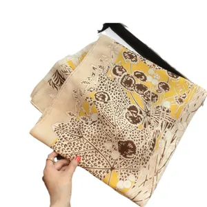 Floral silk scarf with elegant yellow botanical prints and soft fold texture for summer