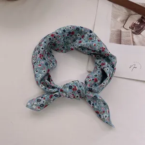 Close-up of light blue floral cotton linen hair band on a textured aesthetic surface