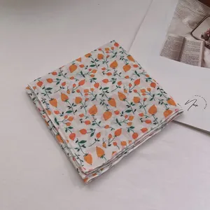 Close-up of soft cotton linen scarf featuring orange berry floral patterns and neat edges