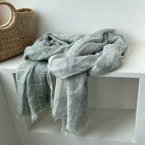 Detail showing the light green textured linen fabric with subtle grid patterns and frayed edges