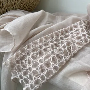 Detail van delicaat bloemenkant borduursel op een lichte linnen katoenen sjaal voor dames