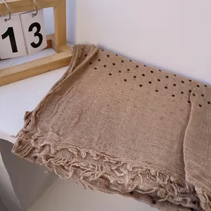 Close-up of linen polka dot scarf with natural frayed edges and breathable texture