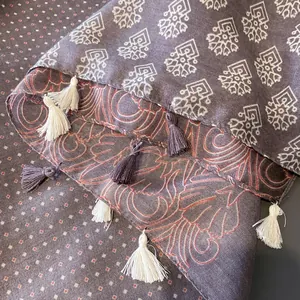 Close-up of printed shawl with floral motifs, geometric patterns and bicolor tassels