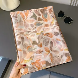 Vue détaillée du châle à imprimé feuilles colorées aux tons chauds de la terre