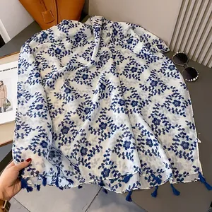 Blue and white porcelain floral scarf with tassels on a desk with accessories
