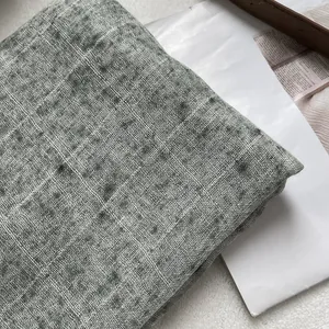 Macro texture of a long grey linen scarf with fringe detailing on a vintage background