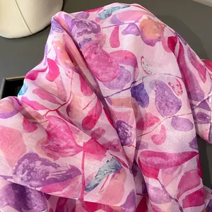Détail d'une écharpe fine en coton et lin avec imprimé feuille aquarelle et texture douce