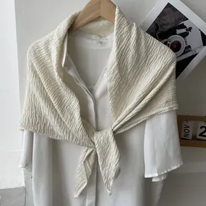 Close-up of beige pleated cotton linen scarf featuring delicate lace embroidery edges