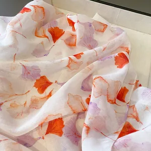 Lightweight white scarf featuring orange and purple ginkgo leaf prints for sun protection