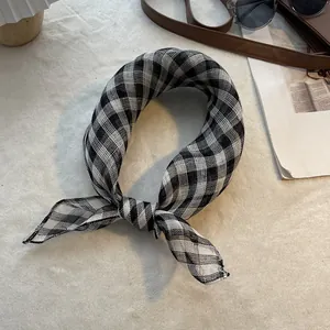 Gros plan du foulard en lin à carreaux noir et blanc avec texture et ourlet détaillés
