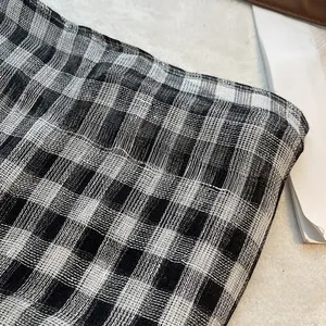 Gros plan sur la texture respirante en lin à carreaux noirs et blancs au tissage fin