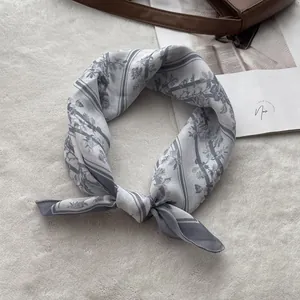Detail of grey-blue floral linen scarf with soft texture on white plush background