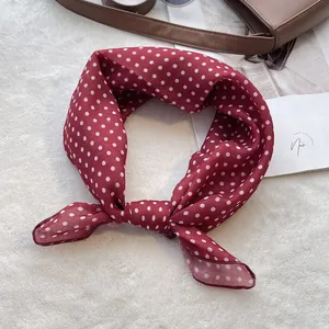 Red and white polka dot cotton square scarf for women on soft white plush background