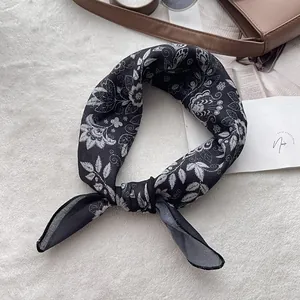 Classic paisley cotton bandana in black and white tied as a stylish headband or scarf