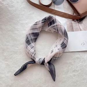 Détail d'un foulard à carreaux en coton et lin avec un nœud élégant sur peluche