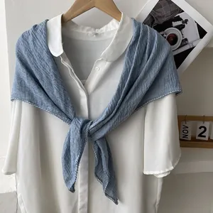 Close-up of blue pleated cotton linen scarf with elegant white wavy edges and soft texture