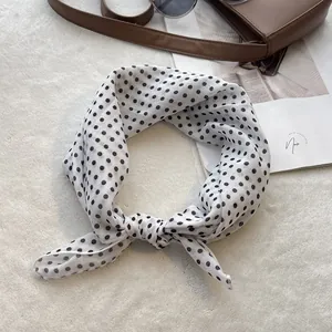 Close-up of knotted black polka dot cotton scarf on a magazine with vintage accessories