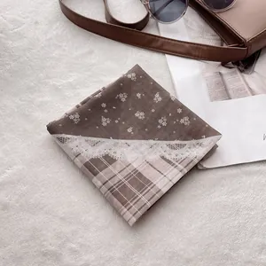 Mise à plat d'un foulard vintage en coton-lin à motifs floraux et sac en cuir