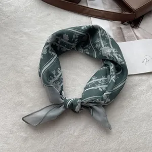 Detailed macro view of retro green floral cotton linen scarf on white plush carpet