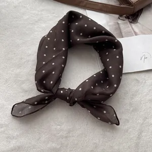 Vintage brown polka dot cotton scarf displayed on a plush white rug for hair styling