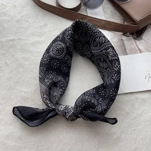 Close-up of black paisley cotton bandana with accessories in a stylish magazine layout