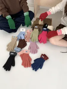 Details von Strickhandschuhen mit elastischen Rippbündchen und EASY-Markenetiketten
