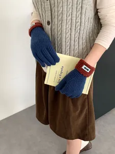 Detail von warmen Strickhandschuhen mit dunkelblauem Rippmuster und braunem Kunstfellbesatz