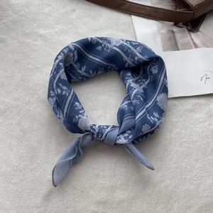 Detailed view of blue floral linen cotton scarf with exquisite hemmed edges on plush background