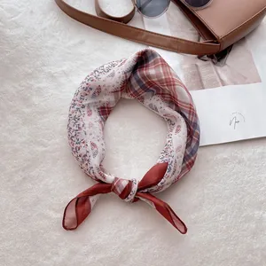 Détail d'un foulard chic en coton et lin avec motif patchwork à carreaux et fleurs