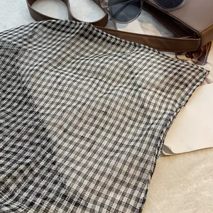 Gros plan sur un tissu en lin léger à carreaux noir et blanc avec texture respirante