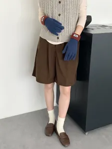 Detail von Strickhandschuhen im Color-Block-Design in Marineblau und Rotbraun mit Etikett