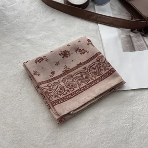 Detailed texture of bohemian paisley and floral print cotton linen scarf on plush background