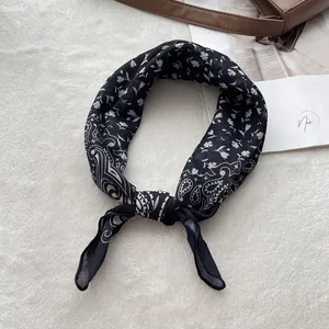 Close-up of black and white paisley cotton bandana with detailed edge stitching and textures