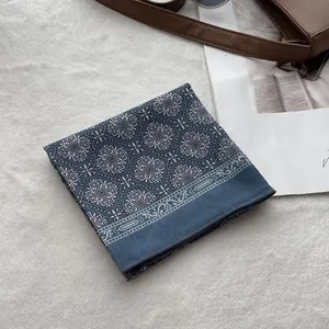 Detailed texture of navy blue cotton headscarf with vintage white geometric pattern